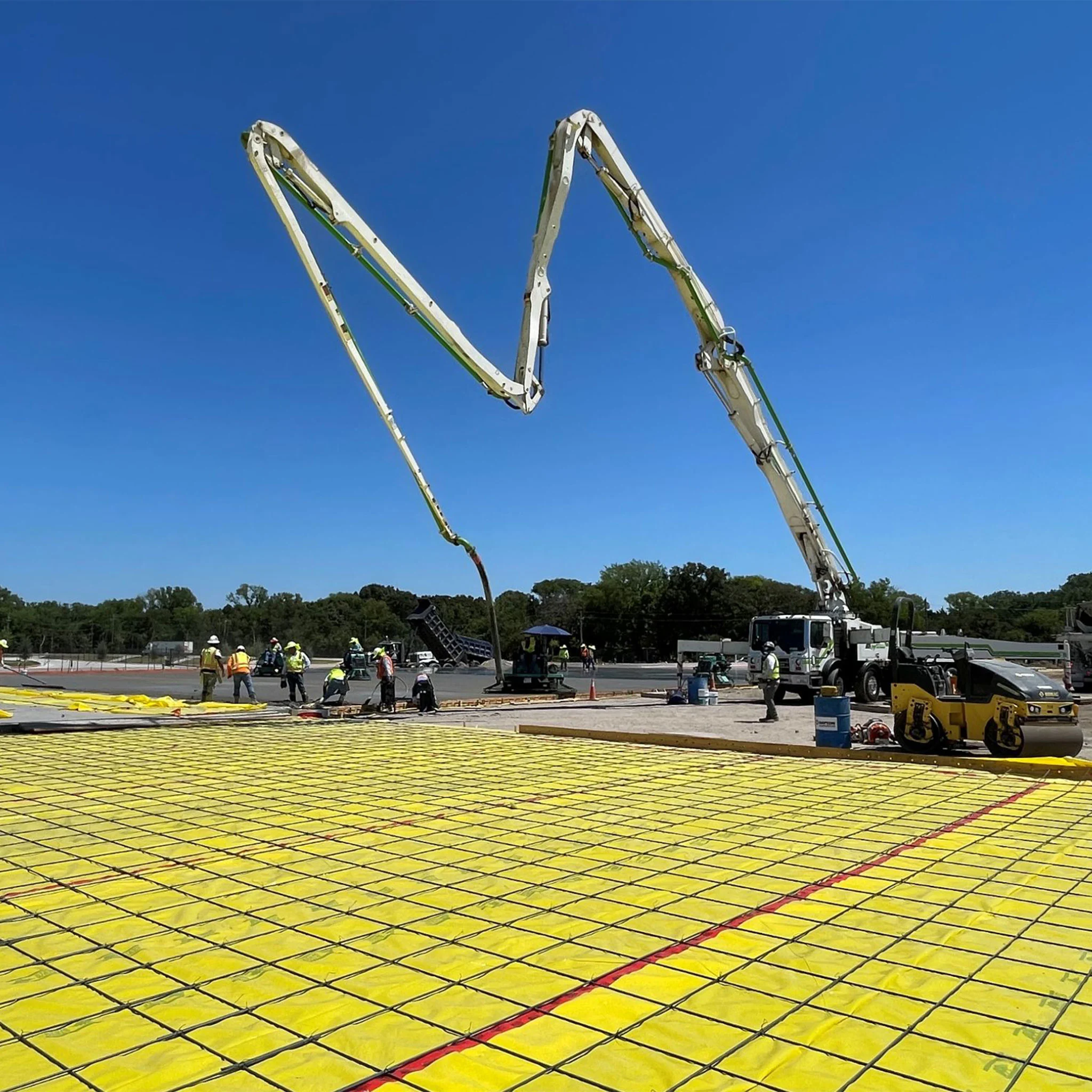 Instalación de barrera de vapor TEGO® WRAP 15-MIL en obra con maquinaria pesada.