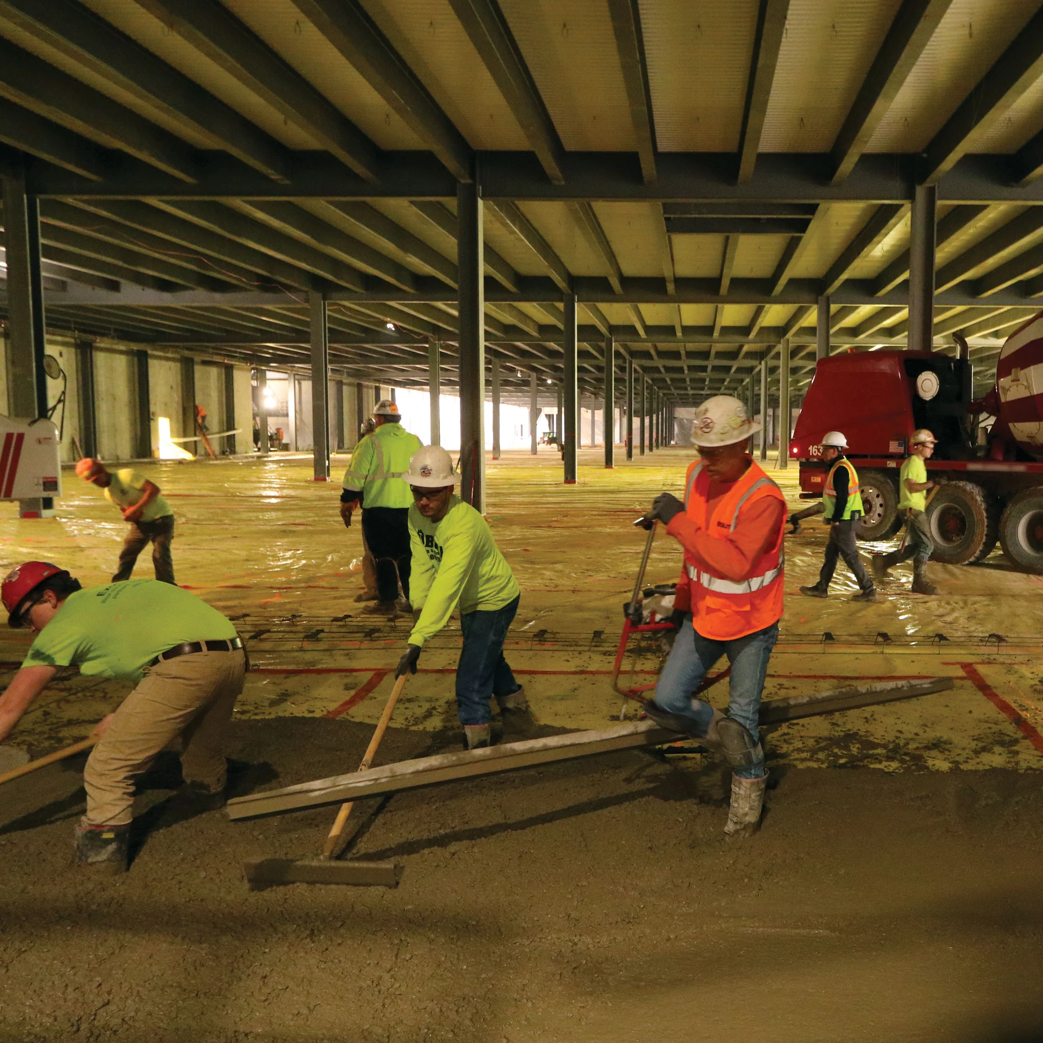 Instalación de barrera de vapor TEGO® WRAP 15-MIL en obra con trabajadores y maquinaria pesada